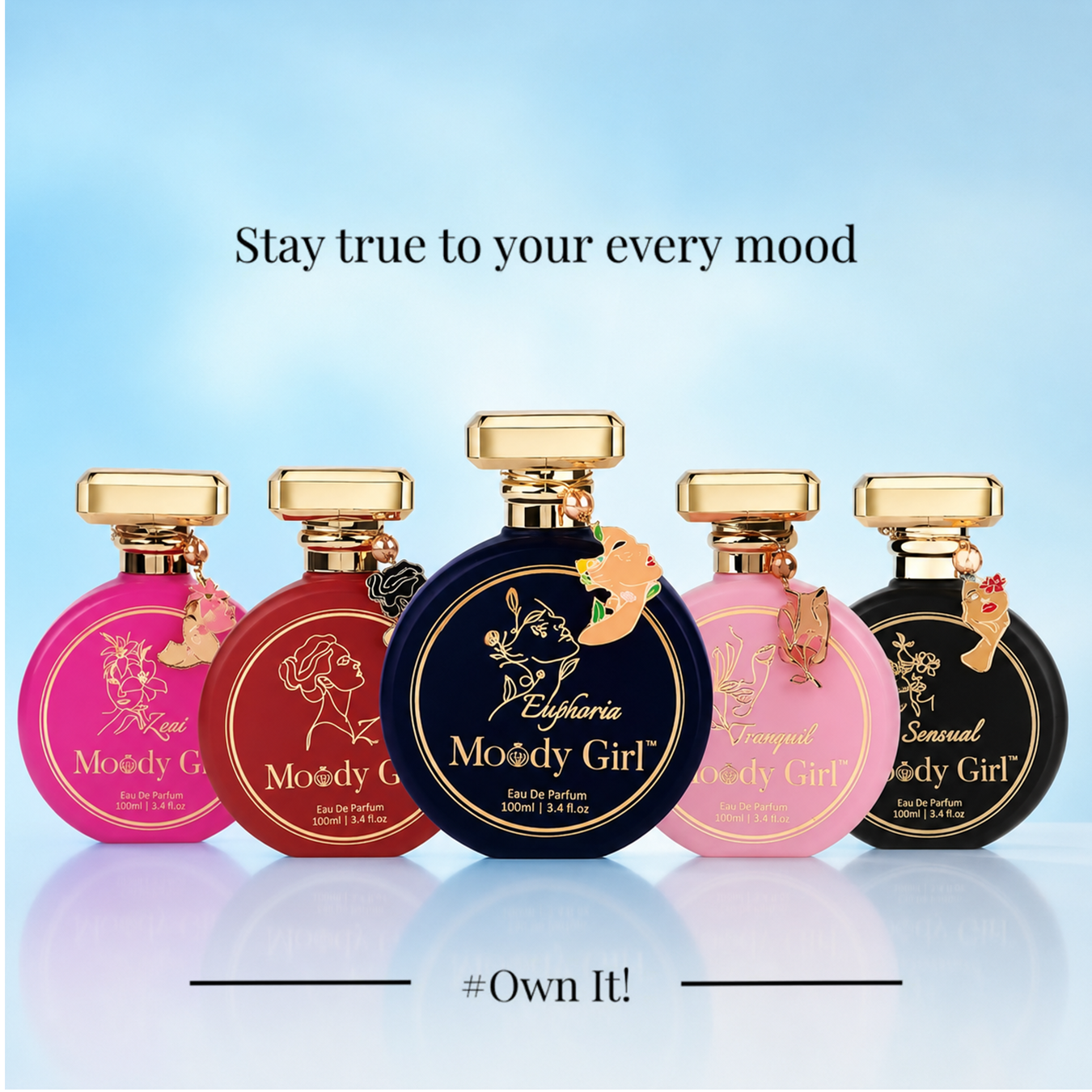 Five perfume bottles from the brand Euphoria, labeled 'Moody Girl' in various colors (pink, red, navy blue, light pink, and black), arranged on a light blue gradient background with text 'Stay true to your every mood' and '#Own It!'.