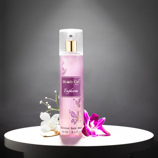 Moody Girl Euphoria shimmer body mist bottle on a dark background with flowers.