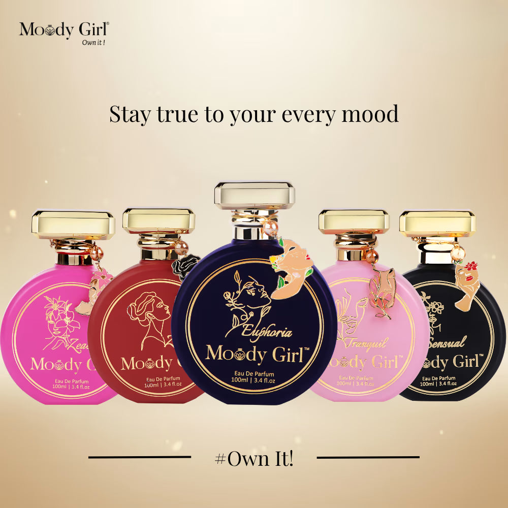 Five Moody Girl perfume bottles with different colored caps on a beige background.