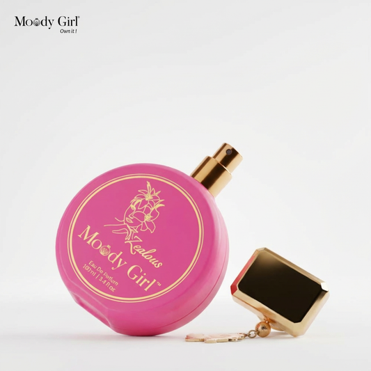 Pink perfume bottle with 'Moody Girl' branding on a dessert-like setup against a gradient background