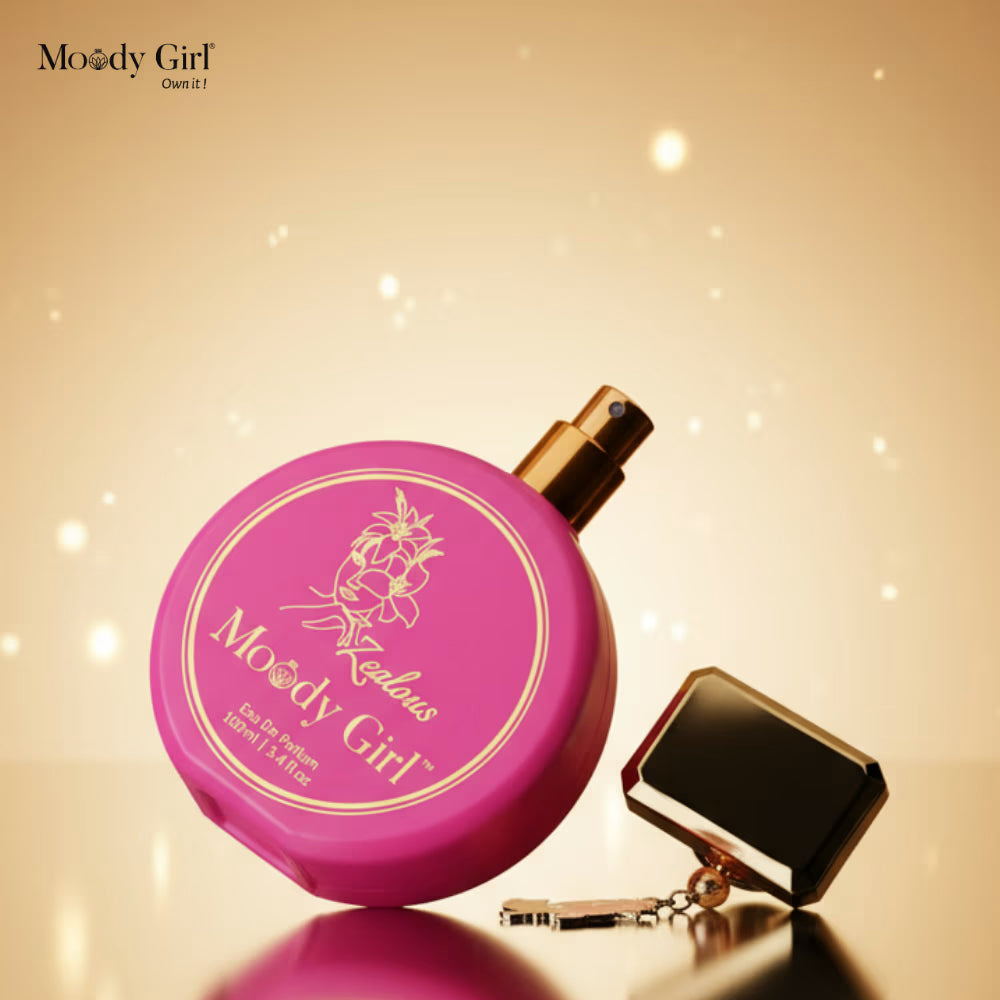 Pink perfume bottle with gold cap and keychain on a beige background, featuring 'Moody Girl' branding.