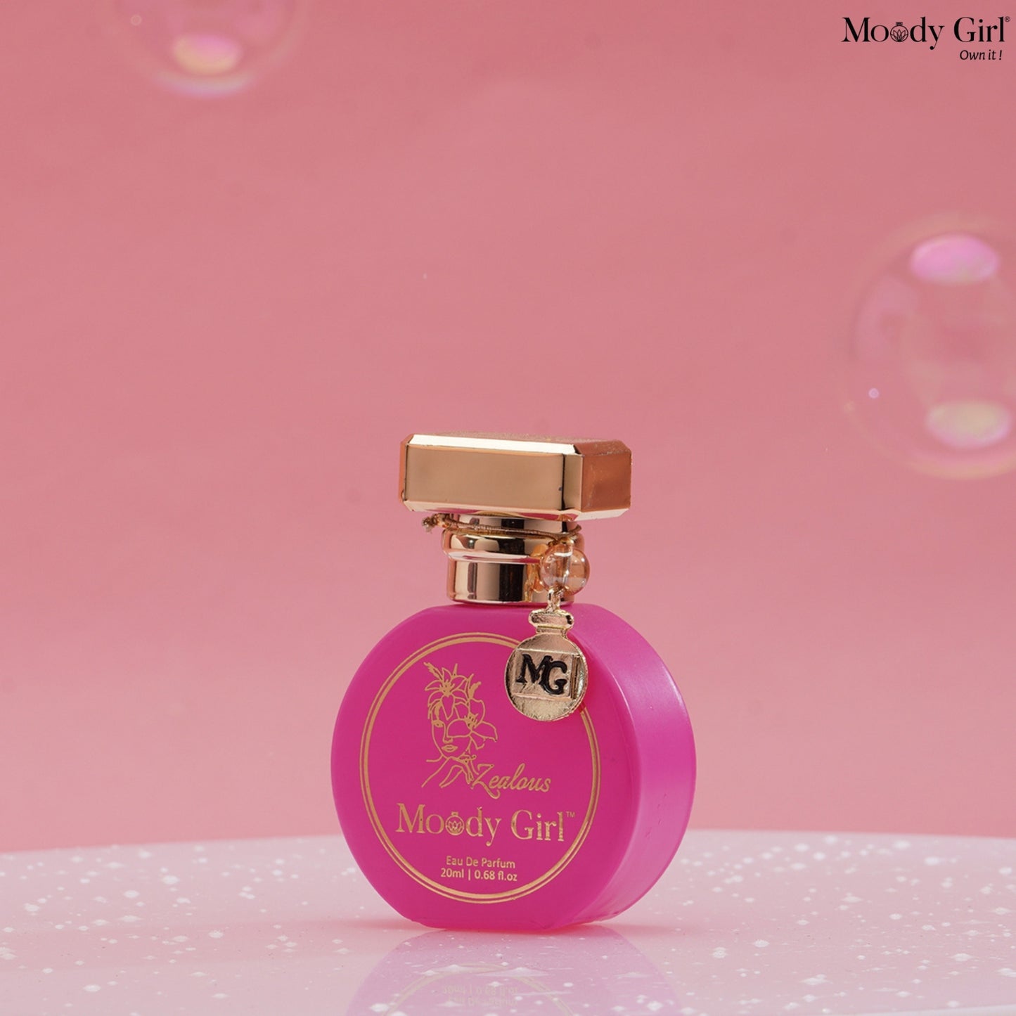 Pink perfume bottle with gold cap on a pink background, featuring 'Moody Girl' branding.