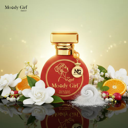 Moody Girl perfume bottle with flowers and oranges on a reflective surface