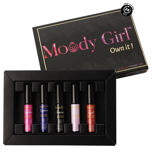 A set of perfume bottles in a display case with 'Moody Girl' packaging in the background.