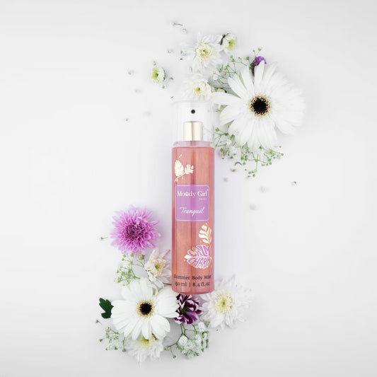 Moody Girl body mist surrounded by flowers on a white background