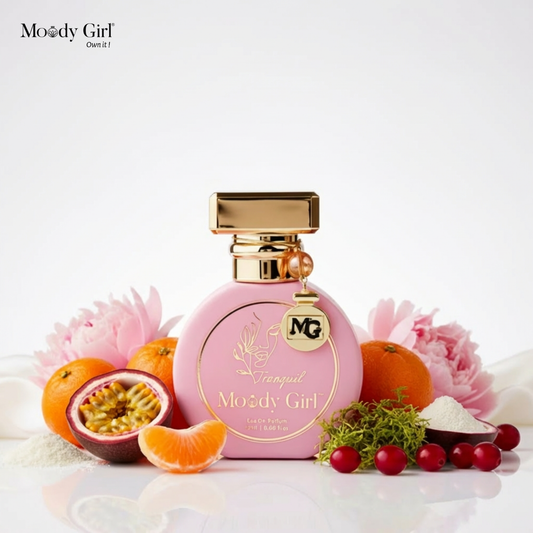 Pink perfume bottle with gold accents on a white background, surrounded by fruits and flowers.