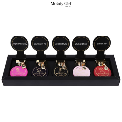 Set of six Moody Girl perfume bottles in a black display case on a white background