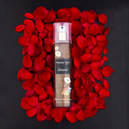 Moody Girl Sensual shimmer body mist surrounded by red rose petals on a black background