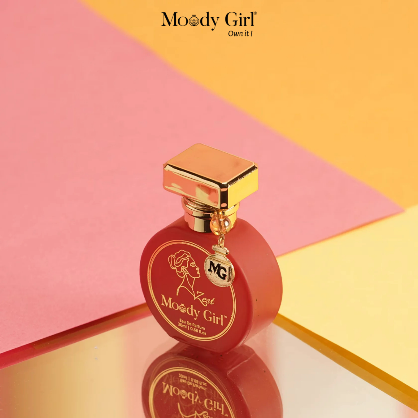 Red perfume bottle with gold cap on a pink and yellow geometric background, featuring the 'Moody Girl' brand.