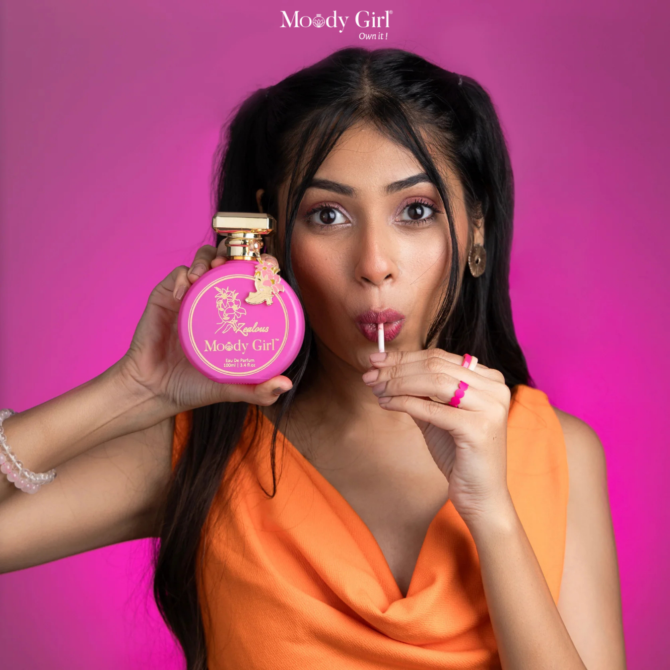 Woman holding a pink bottle with a straw against a pink background