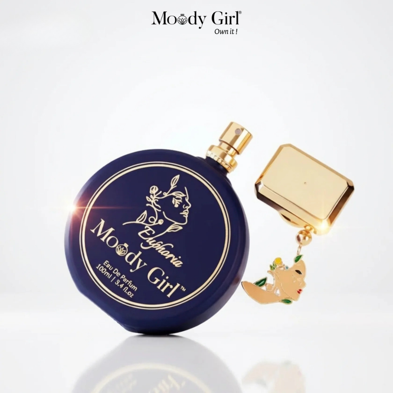 Perfume bottle with gold cap and decorative tag on a white background, featuring 'Moody Girl' branding.