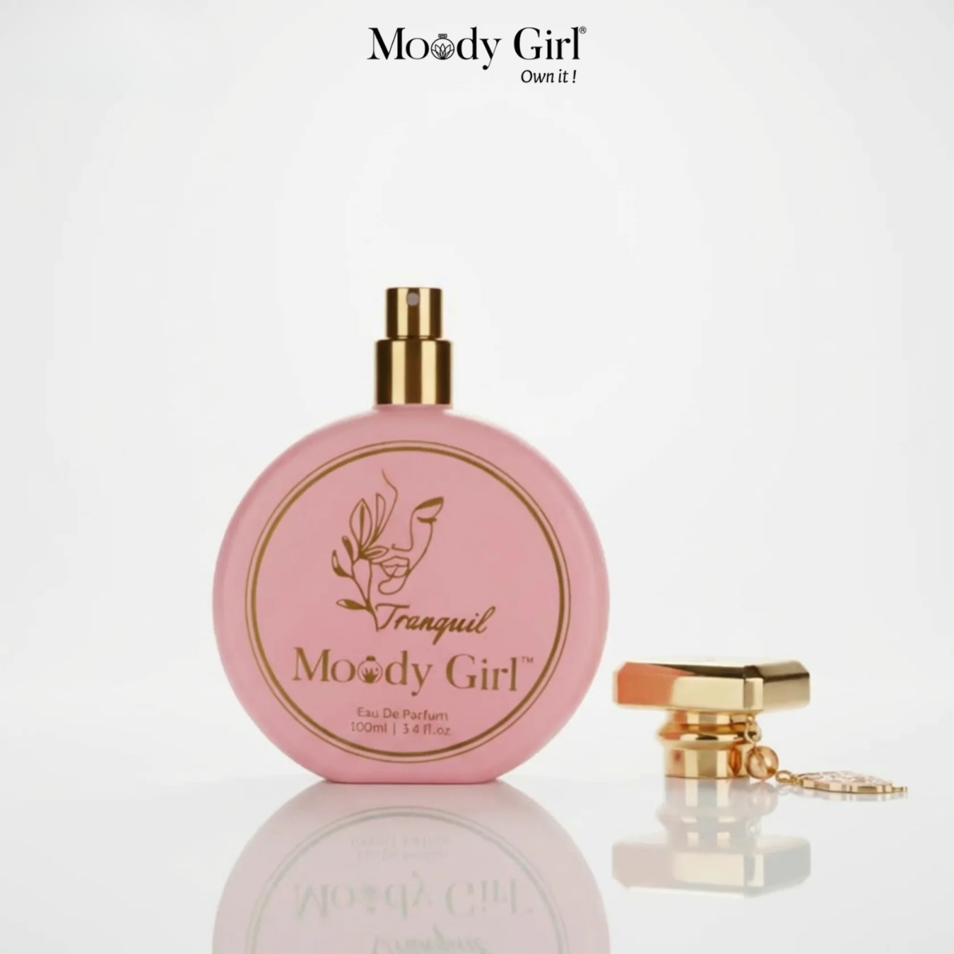 Pink perfume bottle with gold cap and 'Moody Girl' branding on a white background