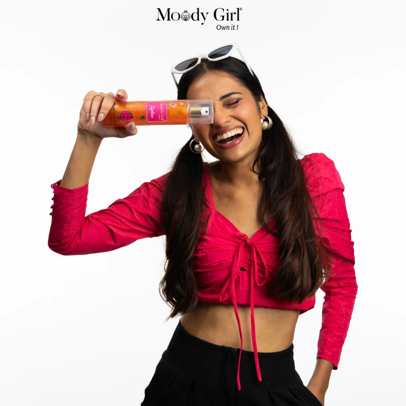Woman in pink top holding a product with 'Moody Girl' branding