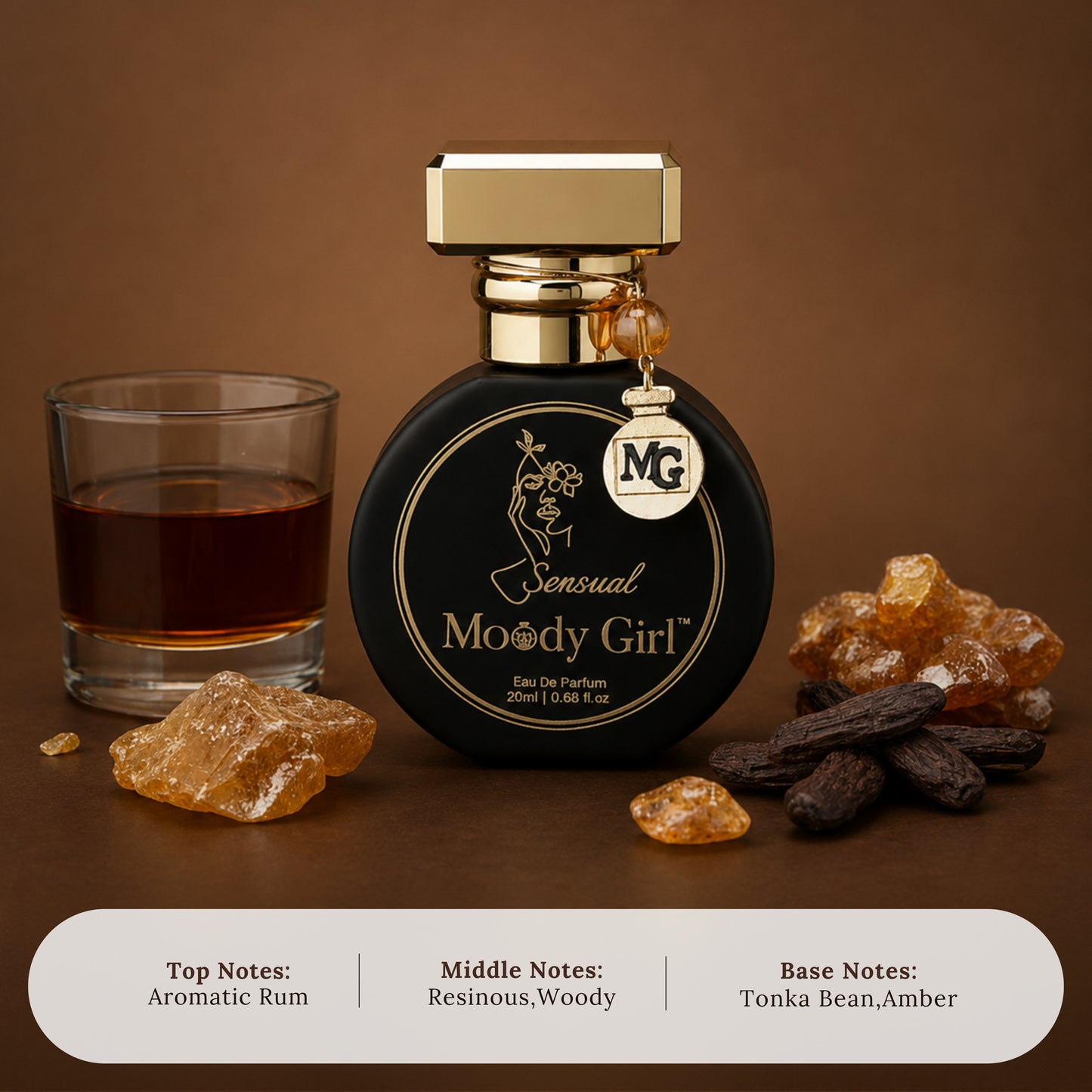 A perfume bottle labeled 'Sensual Moody Girl' with a gold cap and hanging 'MG' charm, styled on a brown surface with a glass of dark rum, amber crystals, and dark beans. A note panel at the bottom lists top, middle, and base notes.