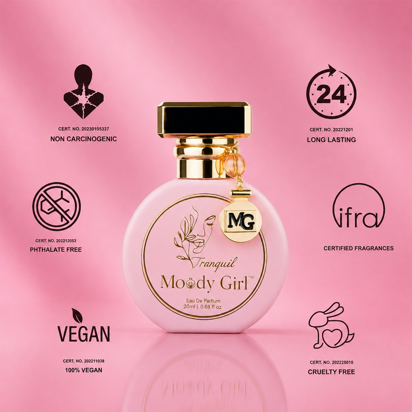 A pink round perfume bottle labeled 'Franquél Moody Girl' with a gold cap and hanging MG charm, centered on a pink background with multiple certification icons and text around it.