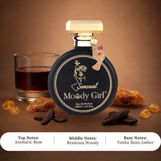 A bottle of Sensual Moody Girl Eau De Parfum is displayed on a brown background with a glass of dark rum, amber sugar cubes, and dark brown spices. A white text banner at the bottom lists the top, middle, and base notes.