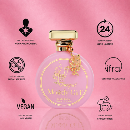 A pink round perfume bottle with a gold cap and gold lettering reading 'Viralpand Moody Girl' is centered on a pink background with several certification and feature icons around it, including Non Carcinogenic, 24h Long Lasting, Phthalate Free, Certified Fragrances, Vegan, and Cruelty Free.