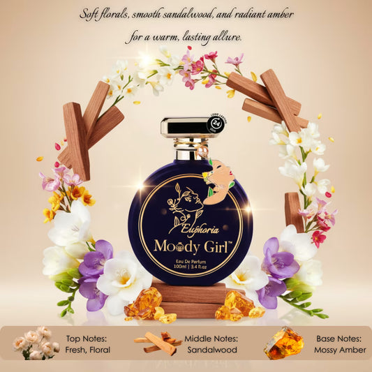 Perfume bottle labeled 'Euphoria Moody Girl' surrounded by flowers and wooden elements on a beige background.