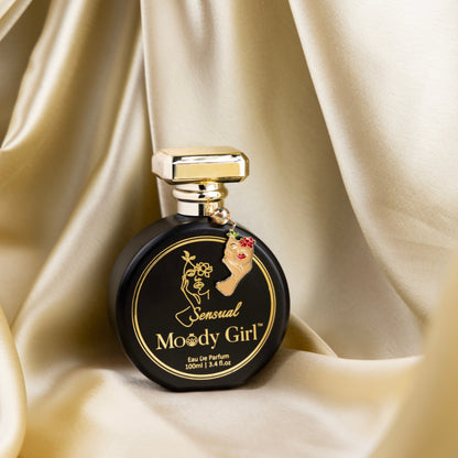 Perfume bottle labeled 'Sensual Moody Girl' on a beige fabric background