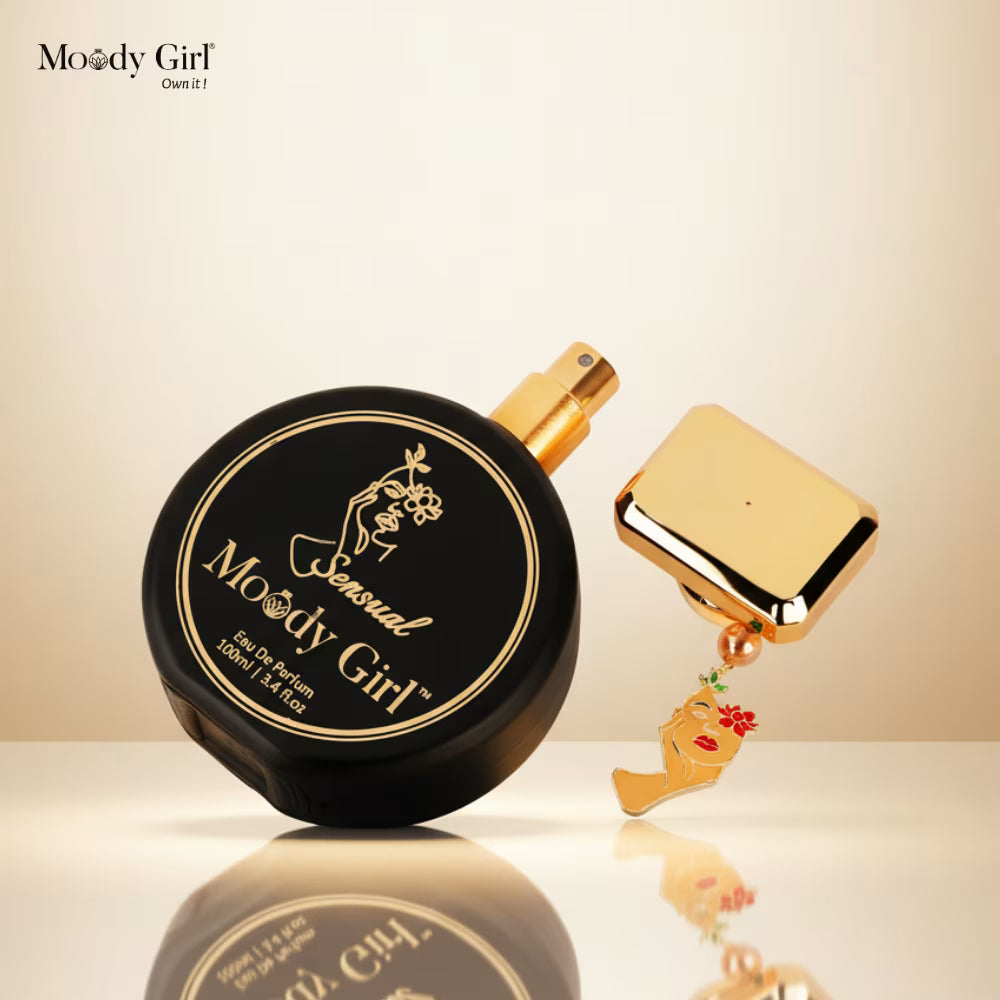Black and gold perfume bottle with 'Moody Girl' branding on a beige background