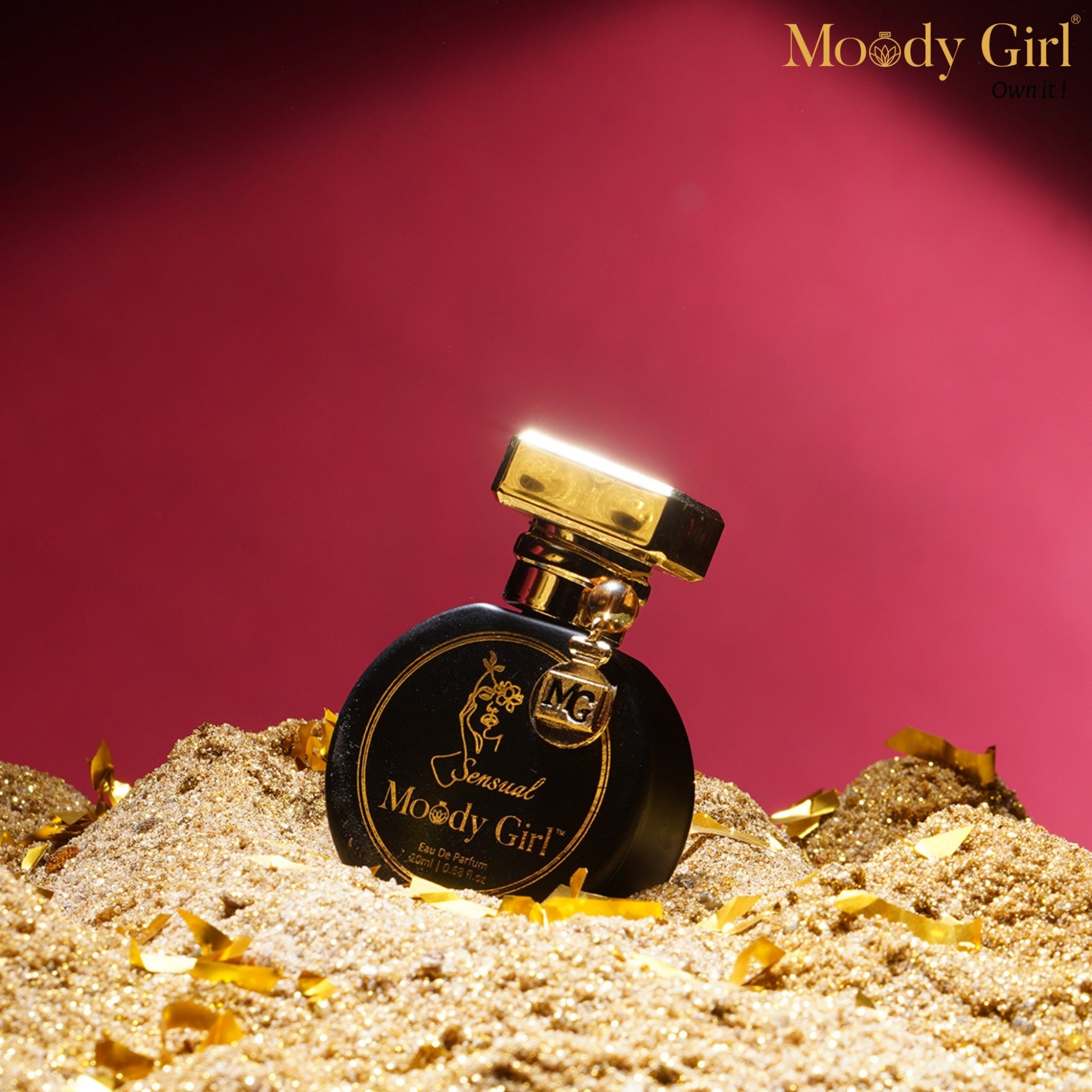 Moody Girl Sensual 20ml Perfume bottle labeled 'Moody Girl' on a sand-like surface with a pink background