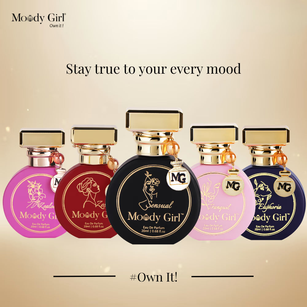 Five Moody Girl perfume bottles with different colored bottles and gold caps on a beige background.