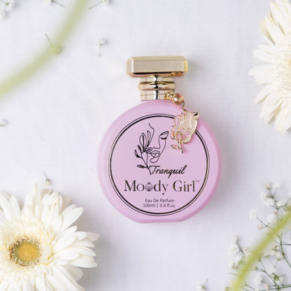 Tranquil 100ml Pink perfume bottle with gold cap on a white background with flowers
