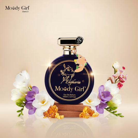 Perfume bottle with flowers and 'Moody Girl' branding on a beige background