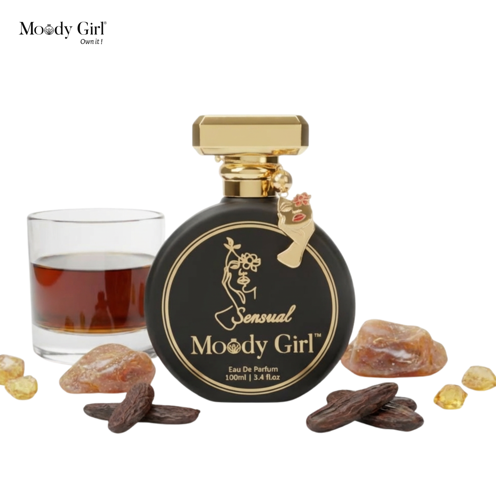 Moody Girl perfume bottle with a glass of liquid and spices on a white background