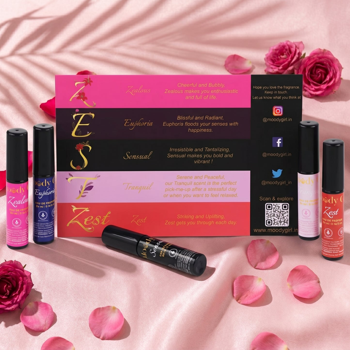 Zesti product packaging and roller bottles on a pink background with roses and petals.