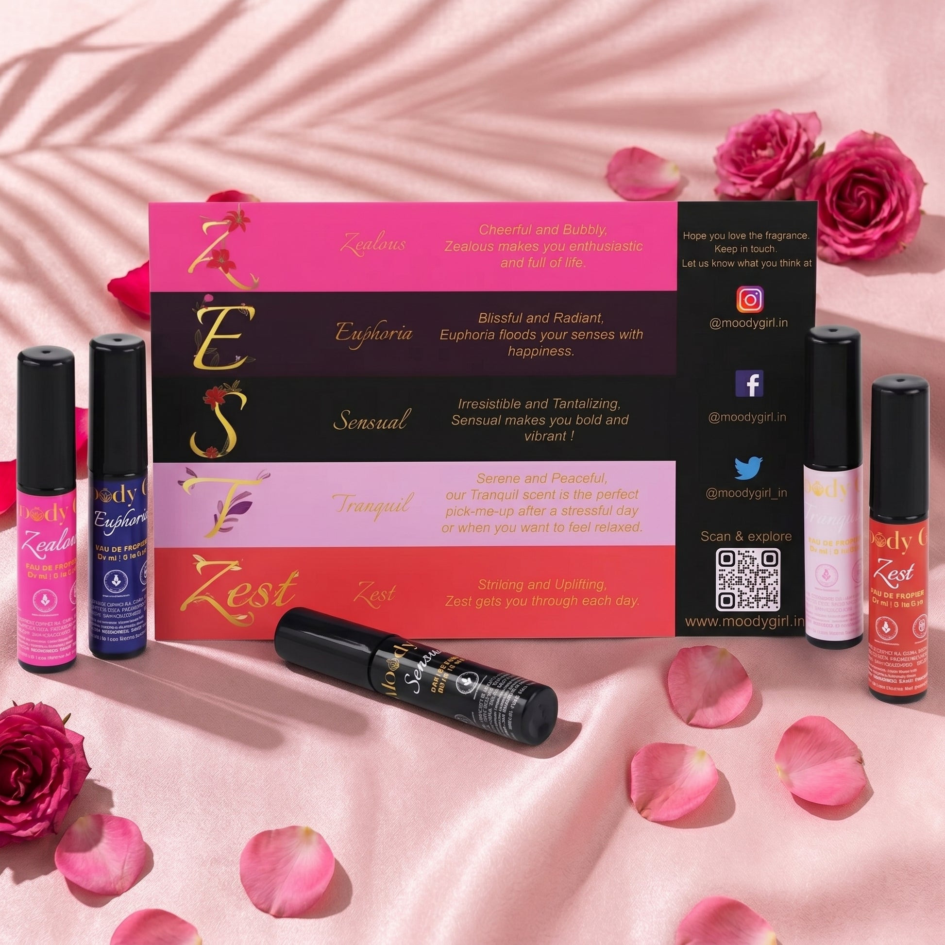 Zesti product packaging and roller bottles on a pink background with roses and petals.