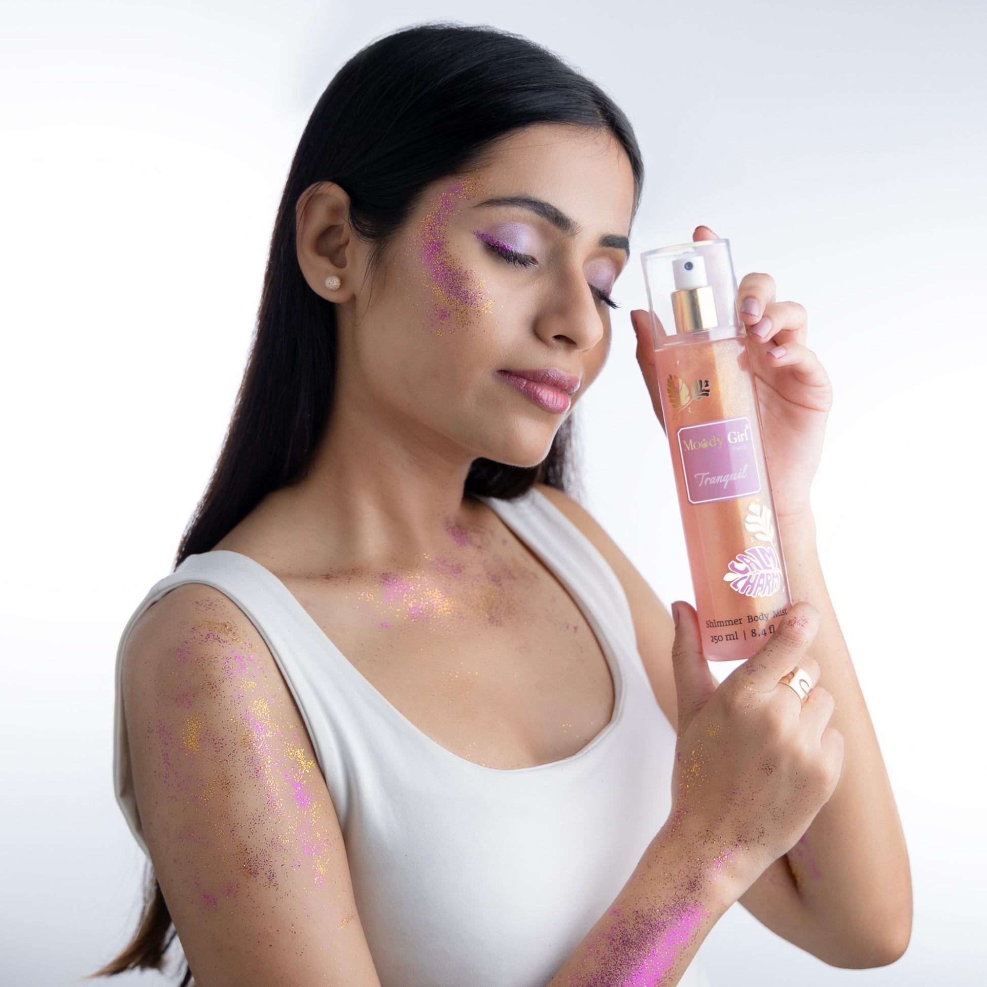 Woman holding a spray bottle with decorative elements on a white background