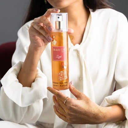 A person holding a bottle of Zest shimmer body mist with visible branding of Moody Girl